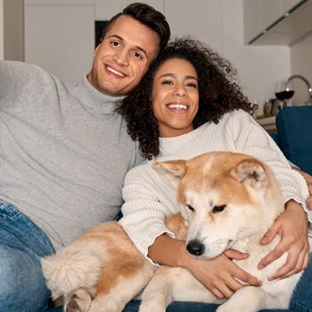 a young man and a young woman holding a sheba inu